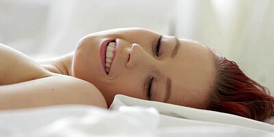 A shy and delicious redhead is playing with her pussy lips