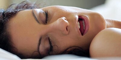 Curly black haired bimbo is using a vibrator on her meaty cunt