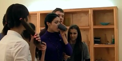 A skinny girl is performing with a guy in front of her friends