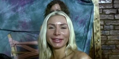 Blonde and brunette women are on the bed, making lesbian love