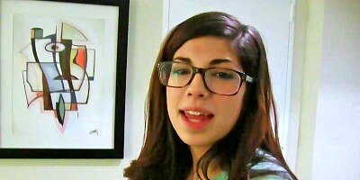 Ava Taylor wears her glasses while she plays with a cock