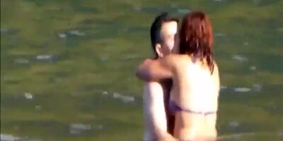 Horny couple having some fun in the water at the beach