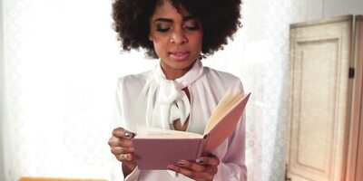 Black social sciences book worm studying with the help of professor's pink pointing rod