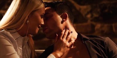 Stylish couple stages their sexual and erotic foreplay in a room with a low lite