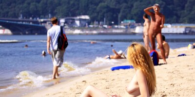 Nude beach girl is having a great time as she spreads her legs