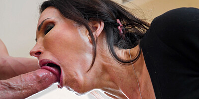 Inked MILF stares at the camera while giving a sloppy blowjob