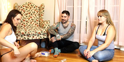 Two girls and one guy are playing a strip game of spin the bottle