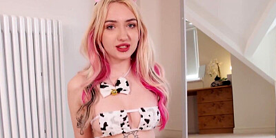 Kitty Marie wears a cow outfit while playing with a toy