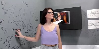 Nerdy brunette, Michele James is sucking a big, black cock through a gloryhole and trying to ride it