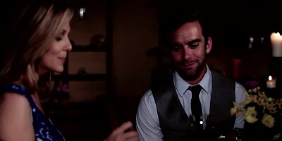 A blonde is having a romantic dinner with her lover in the dark